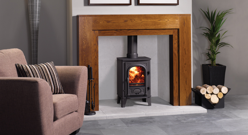 Multi-fuel version of the Stovax Stockton 4 stove in Matt Black, burning logs.  Shown with Stovax Alborg mantel and Triangular black log holder.