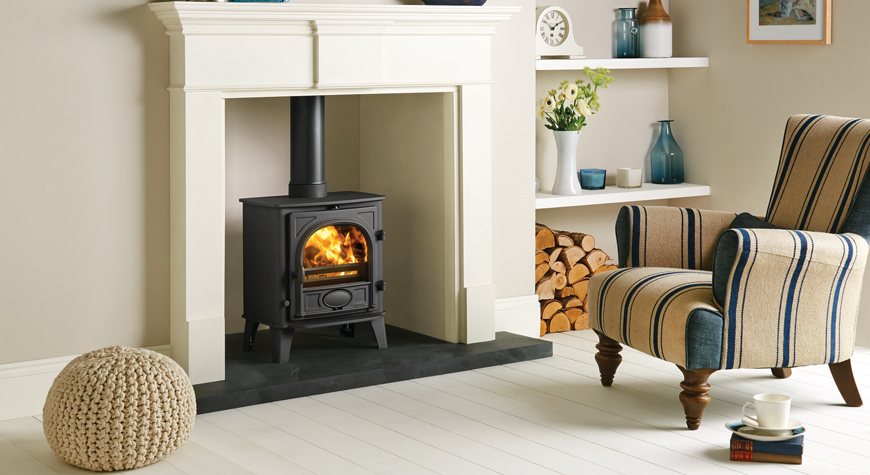  Multi-fuel version of the Stovax Stockton 5 stove with external riddling. Shown here in Matt Black, burning logs with Pembroke mantel in White also available from Stovax.
